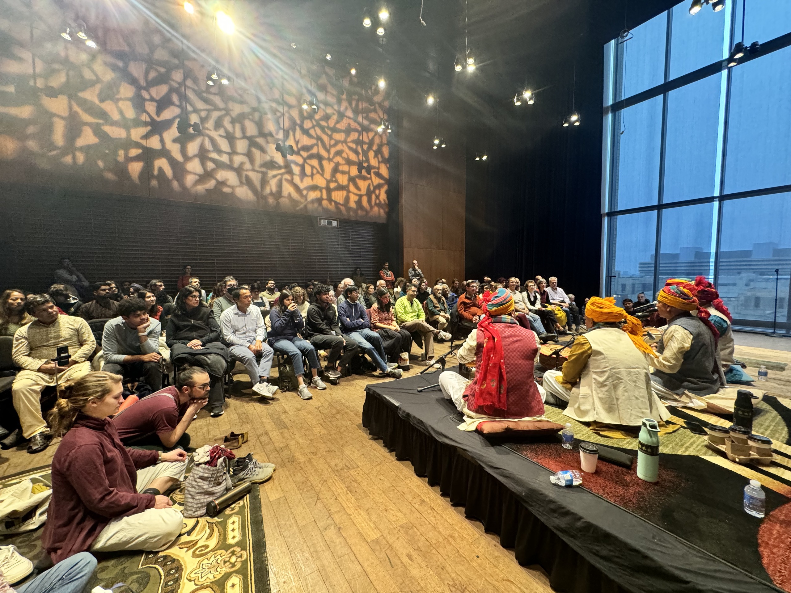 Prahlad Singh Tipaniya and ensemble performing for a large audience