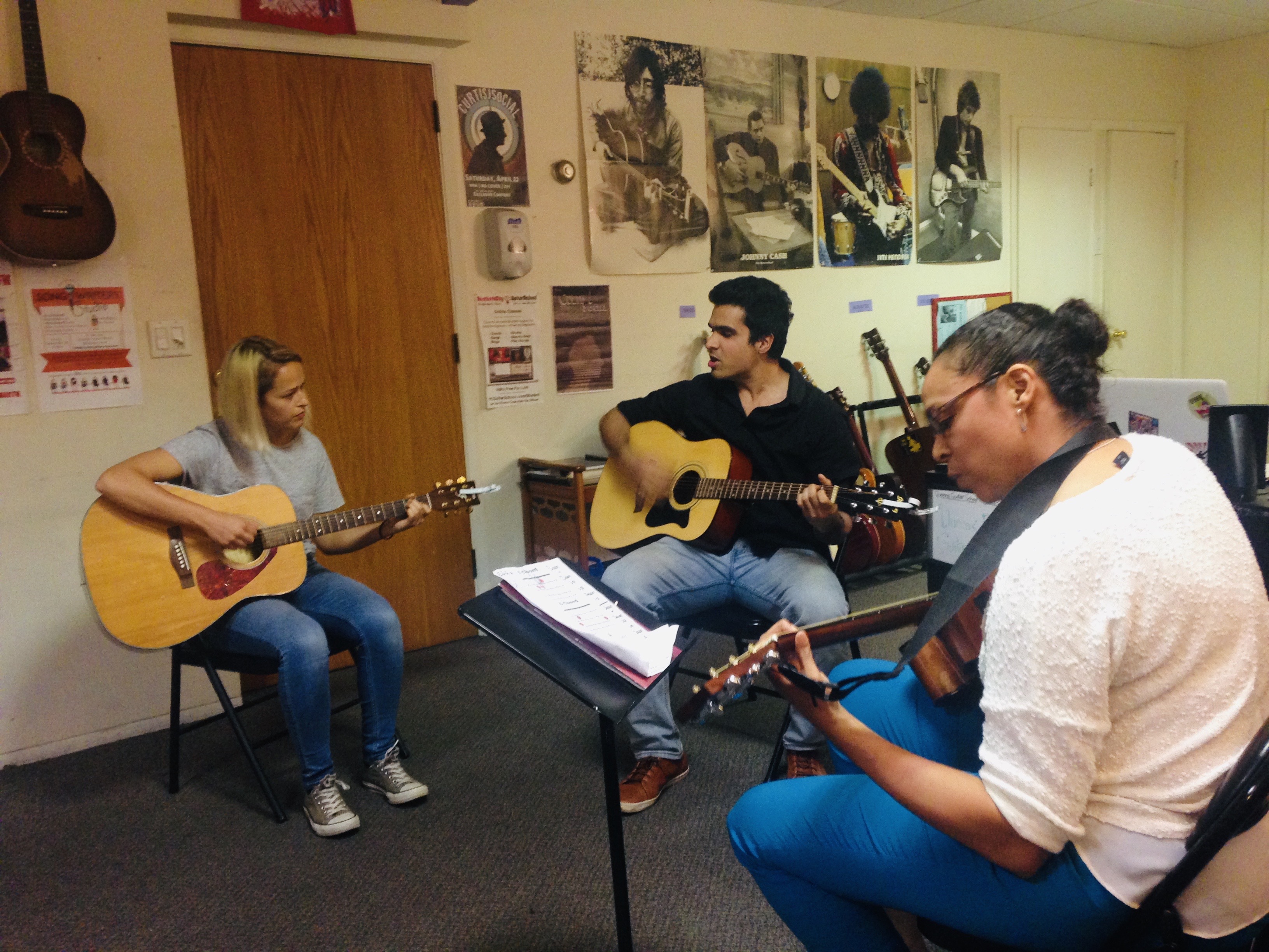 Priyal Maheshwari singing and playing guitar in a small group rehearsal