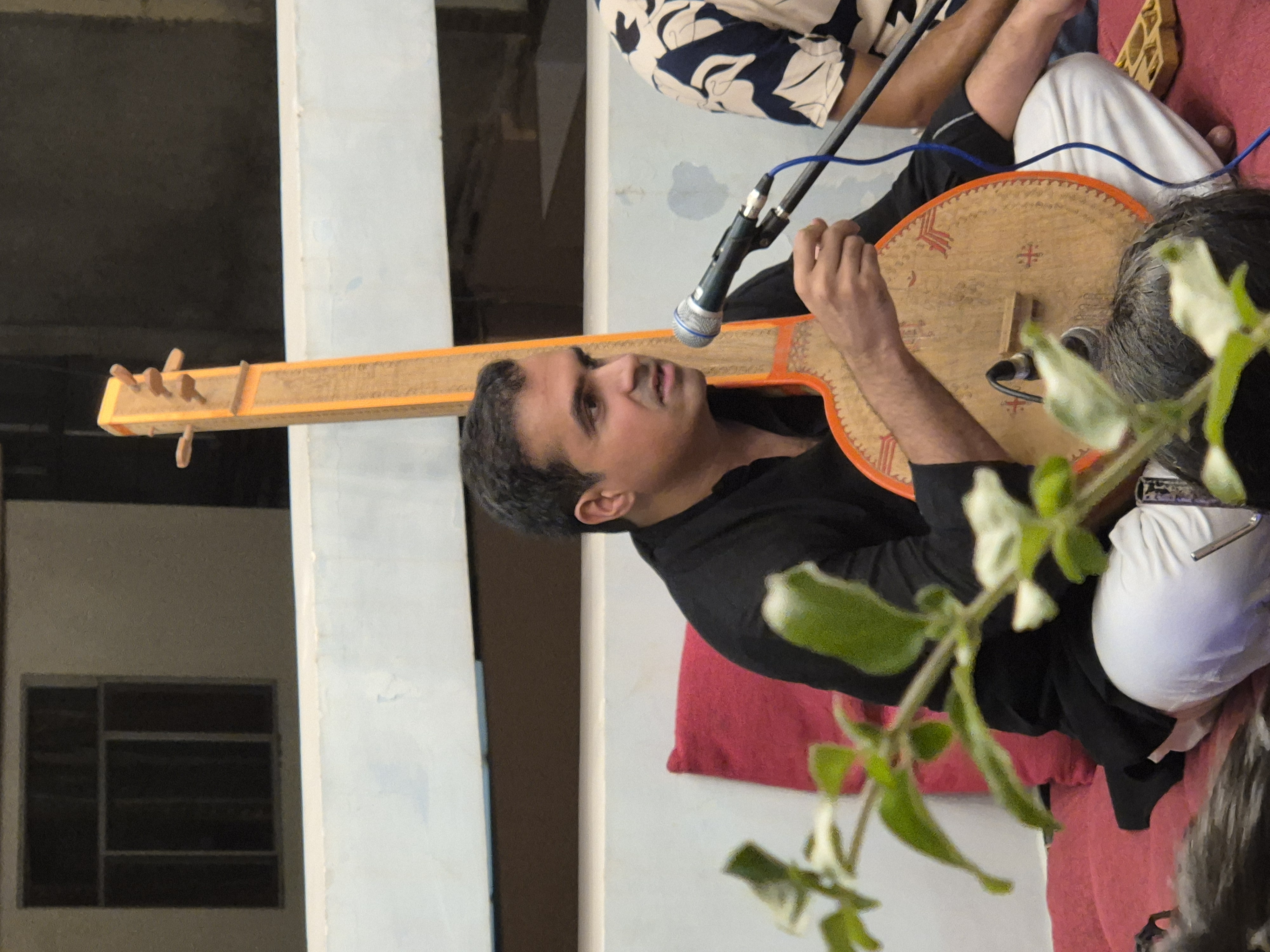 A solo singer performing with a traditional tambura